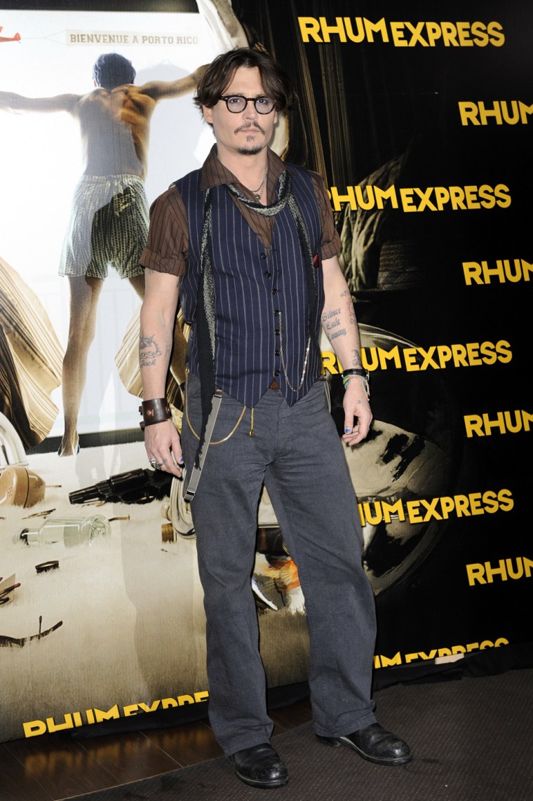 Image: Actor Depp poses for photographers as he arrives for the premiere of the film \"The Rum Diary\" in Paris